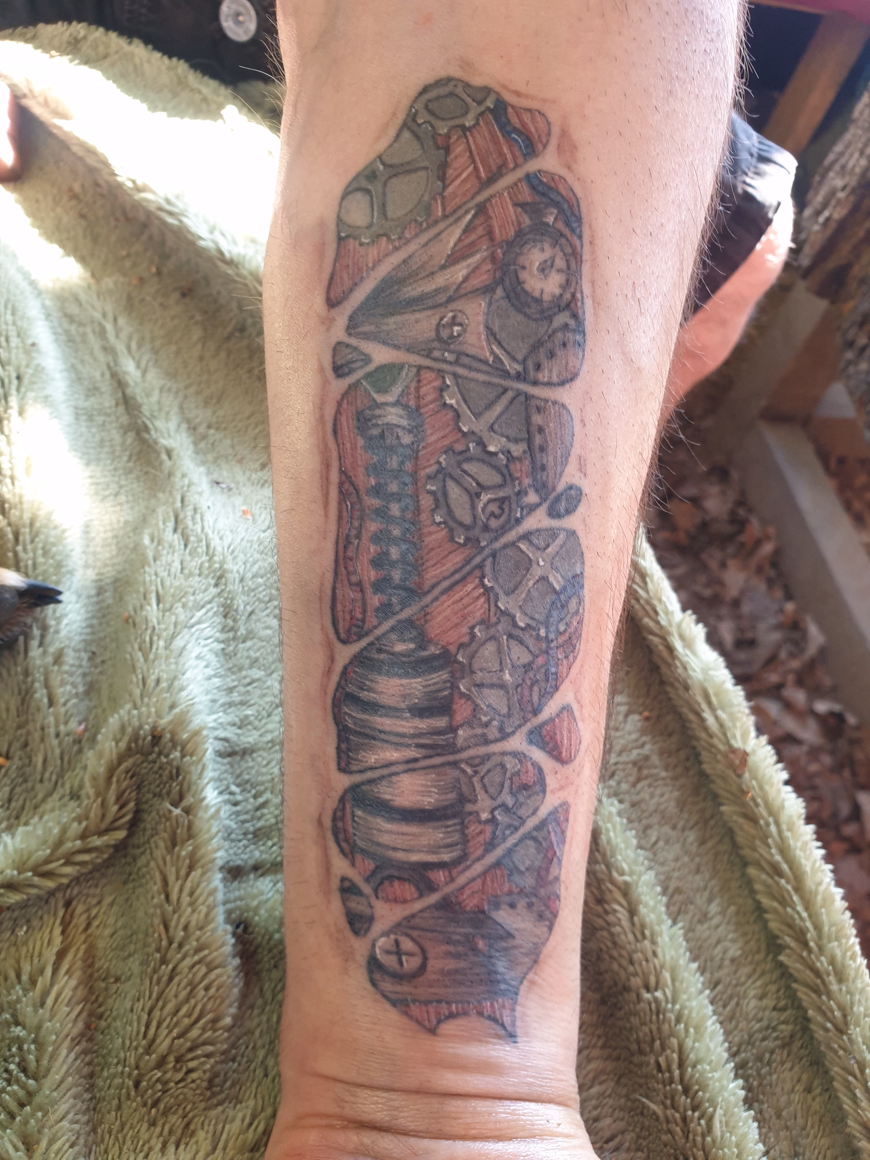Tatouage mécanique en couleur réalisé par Sarah Fleur