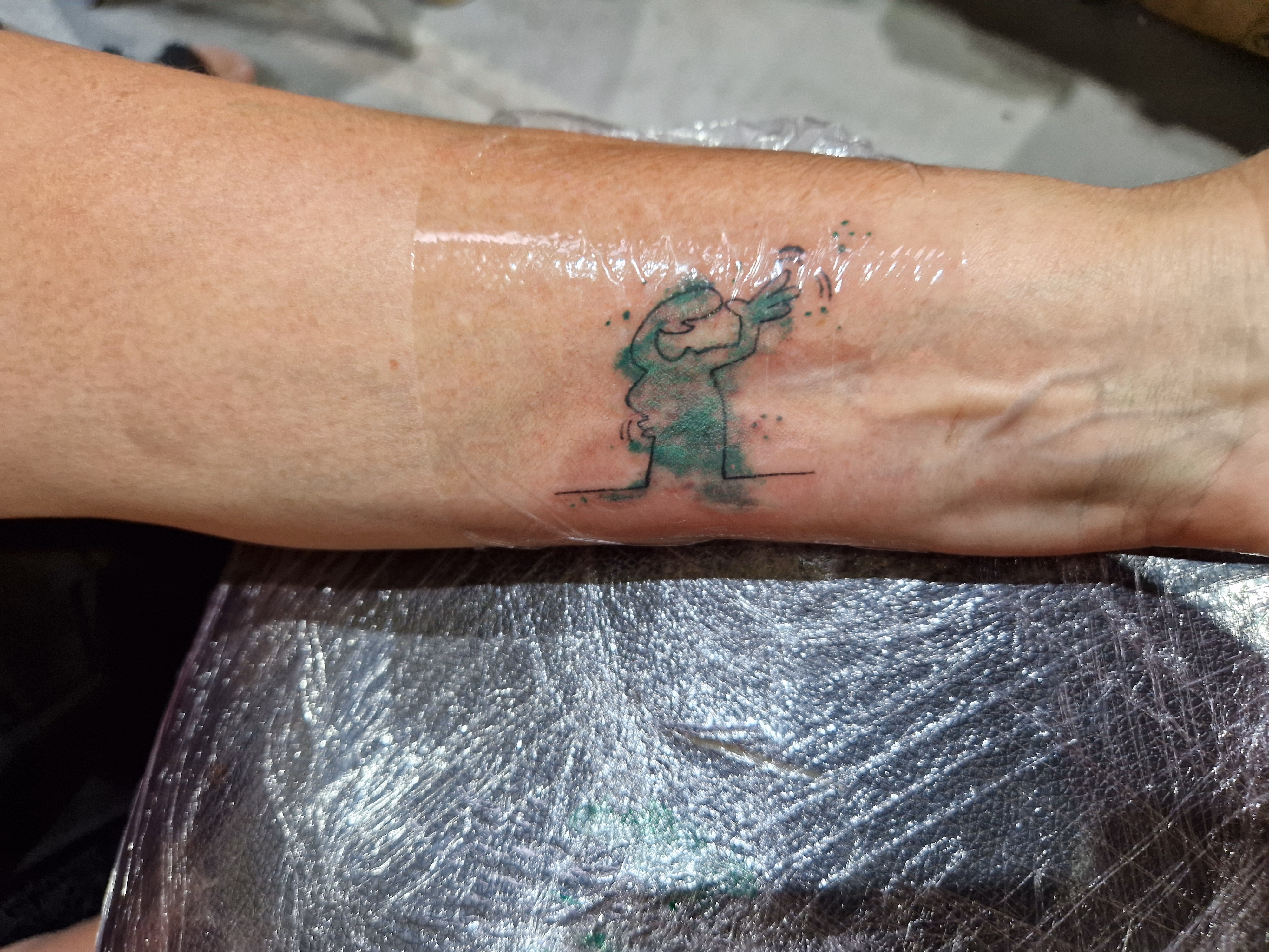 Petit tatouage vert minimaliste réalisé par Sarah Fleur